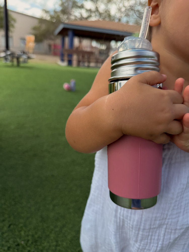 Kind houdt de Pura thermos rietjesfles Rose vast