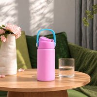 RVS drinkfles roze op een houten bijzettafel