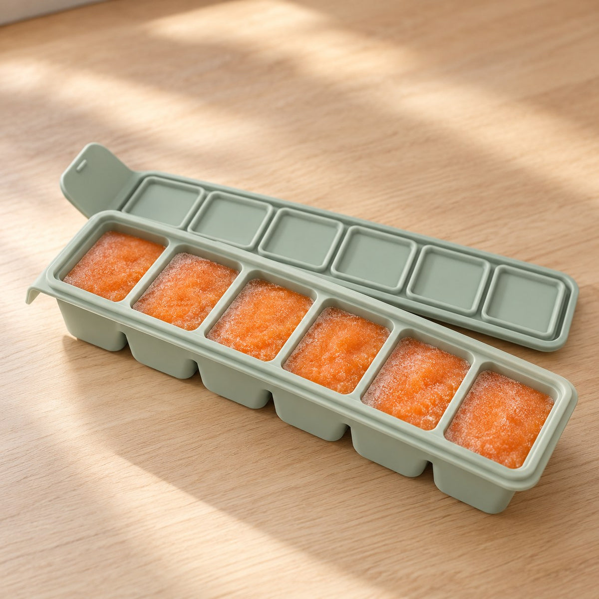 Siliconen vriestray met bevroren wortelpuree en deksel ernaast